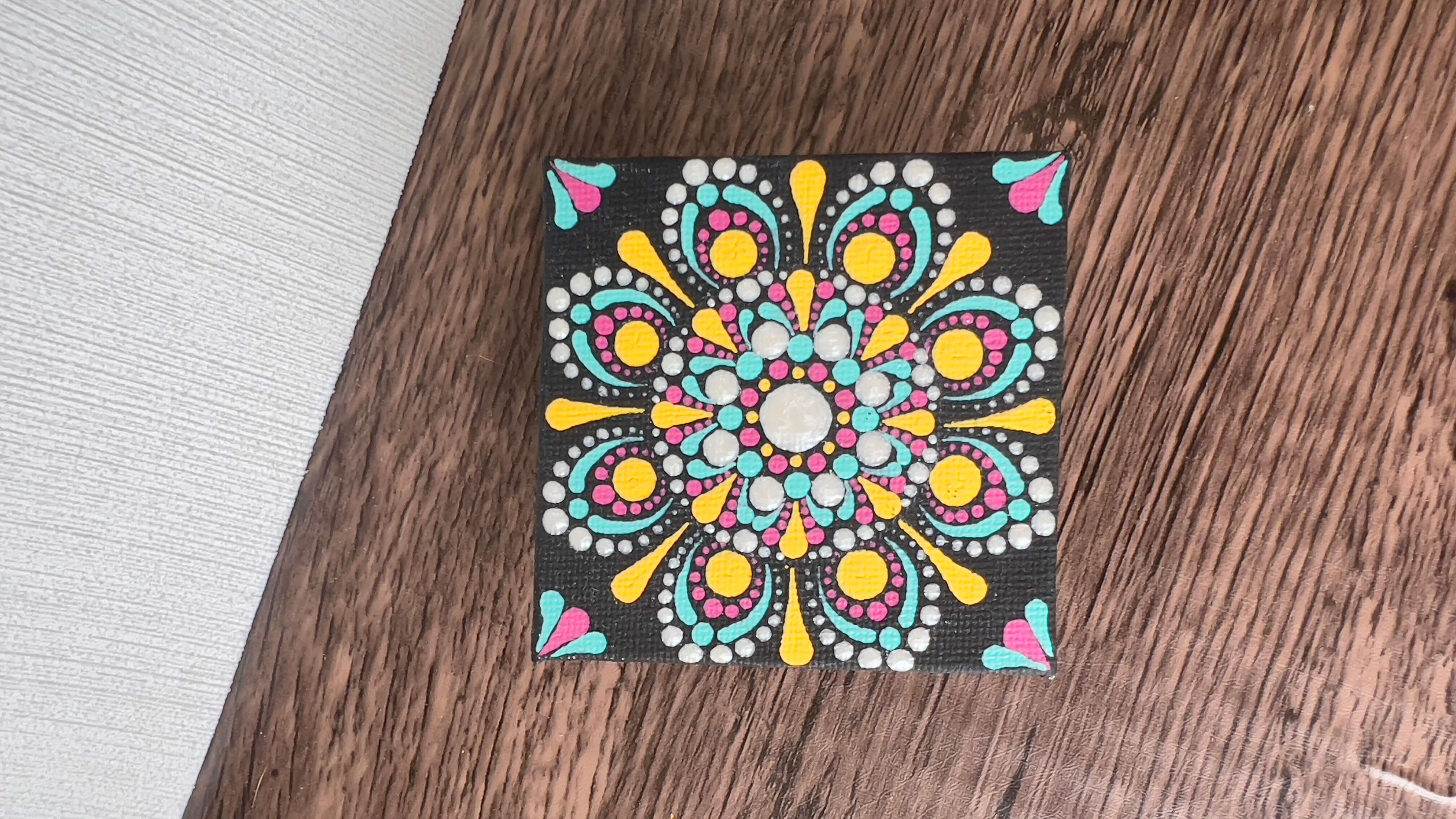 Yellow, teal, pink, white dot mandala on small square canvas